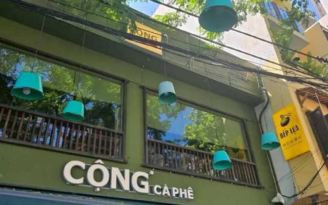 緑の外壁とランプが下がるカフェの看板