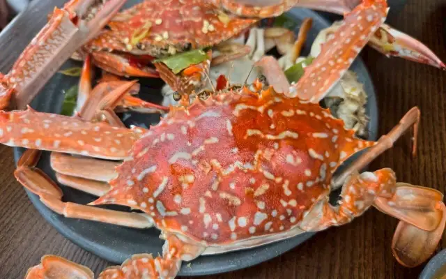 皿に盛られた赤く茹でられたワタリガニ