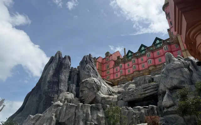 岩山の上に建つピンク色の洋館風の建物
